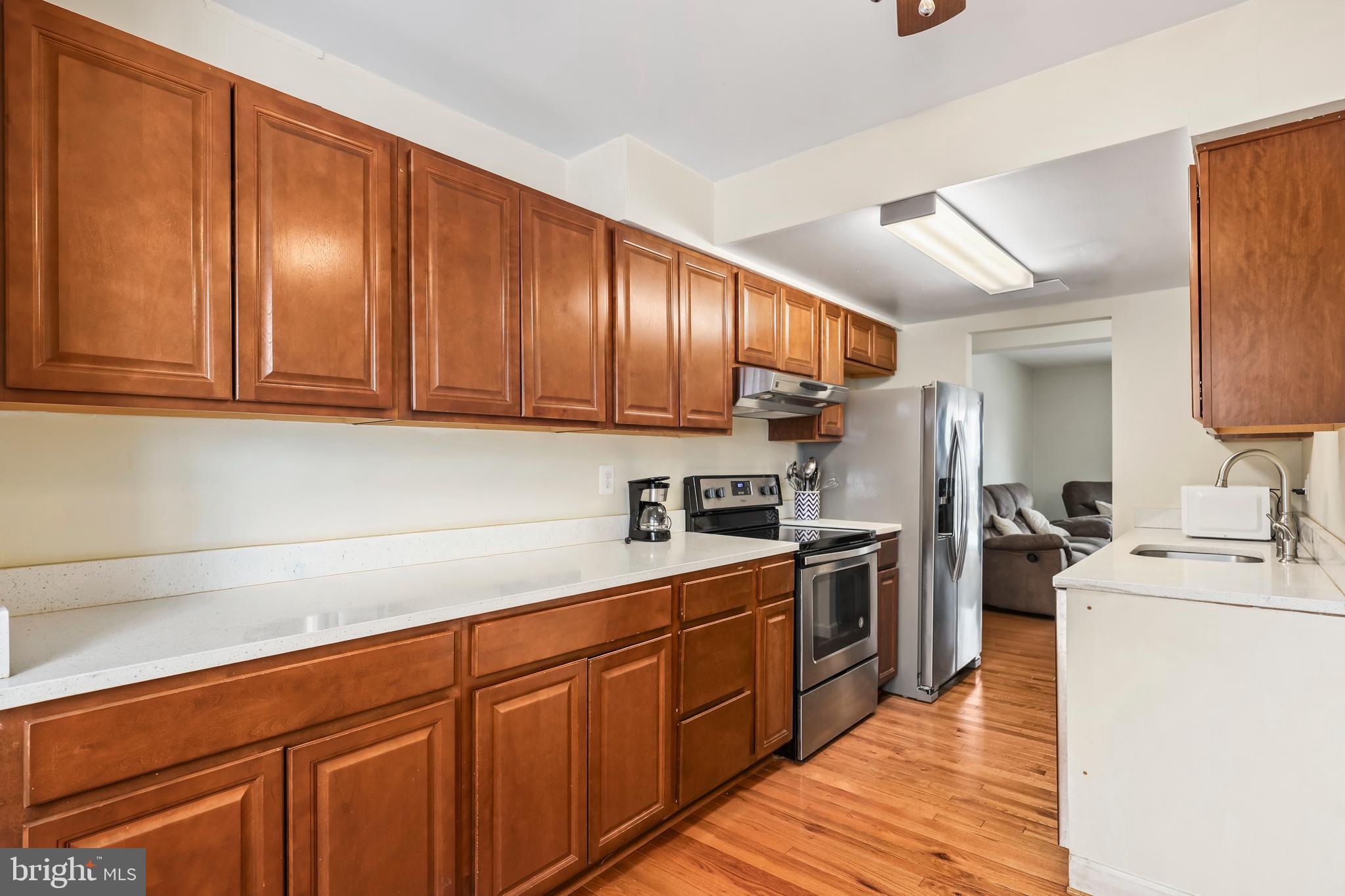 302 Giles Place Sterling, VA 20164 - Photo 2 of 23 a kitchen with granite countertop wooden cabinets stainless steel appliances a sink and wooden floor