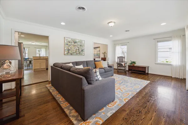 a living room with furniture and a wooden floor