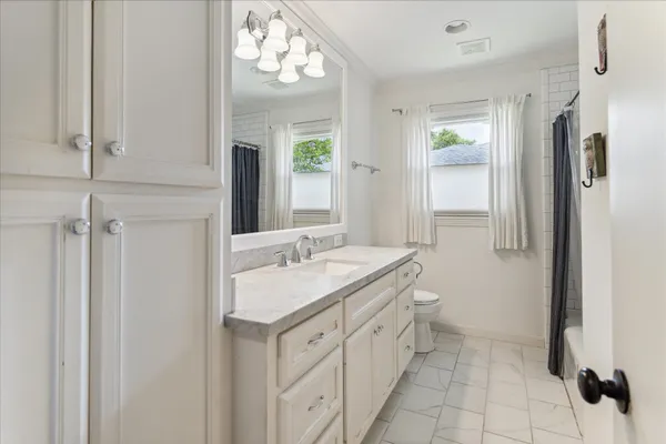 a bathroom with a granite countertop sink a mirror and shower