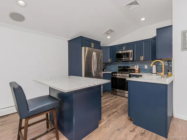 a kitchen with kitchen island a cabinets counter space and stainless steel appliances
