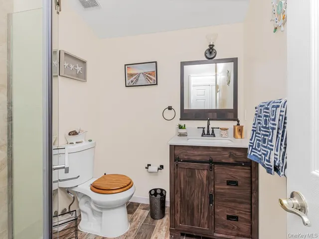 a bathroom with a granite countertop toilet sink and mirror
