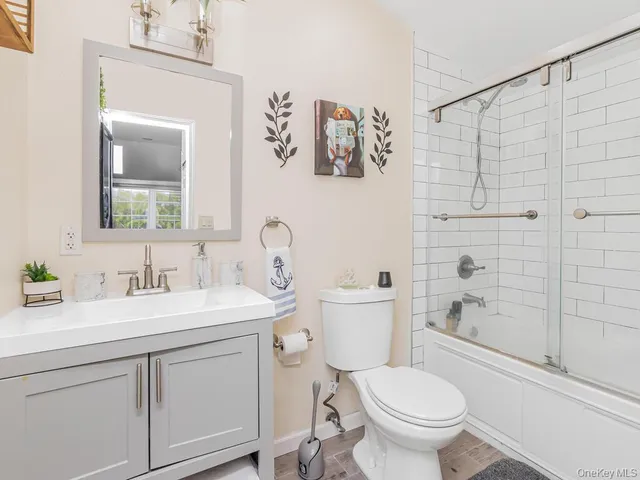 a bathroom with a toilet sink vanity tub and mirror