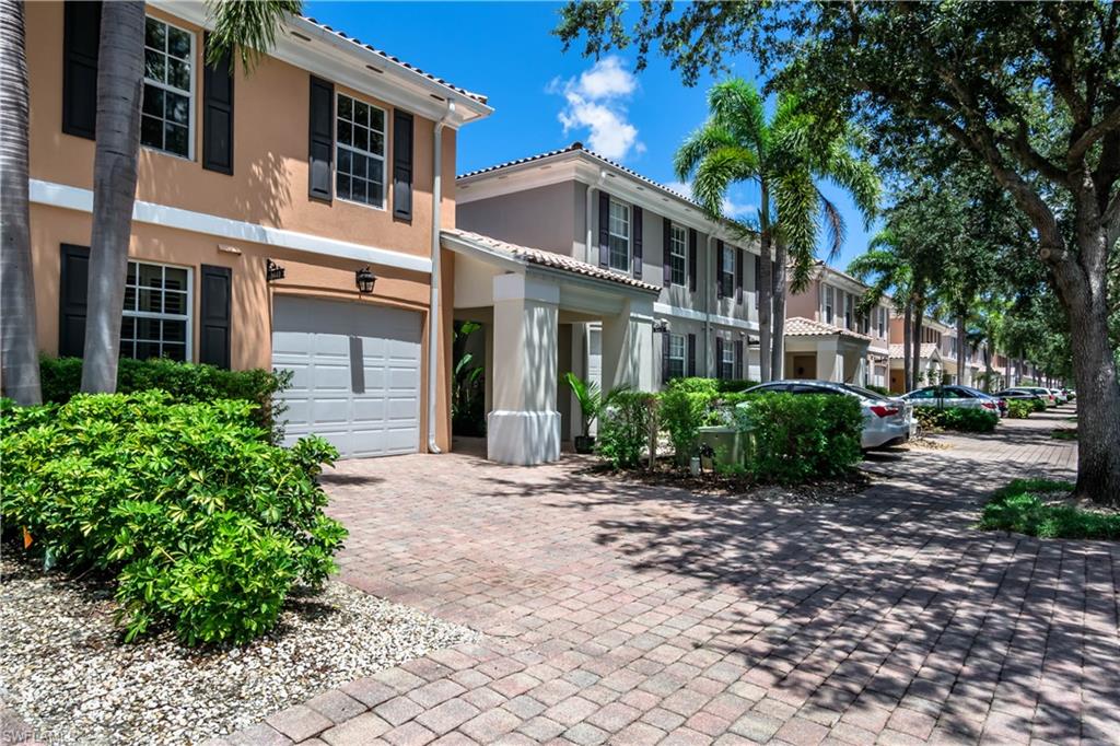 5441 Cove Circle Naples, FL 34119 - Photo 1 of 25 a front view of a house with a garden