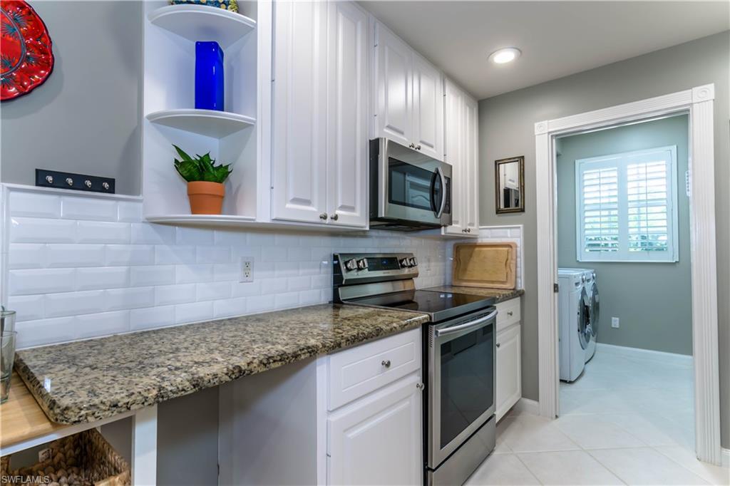 5441 Cove Circle Naples, FL 34119 - Photo 13 of 25 a kitchen with stainless steel appliances granite countertop a sink stove and microwave