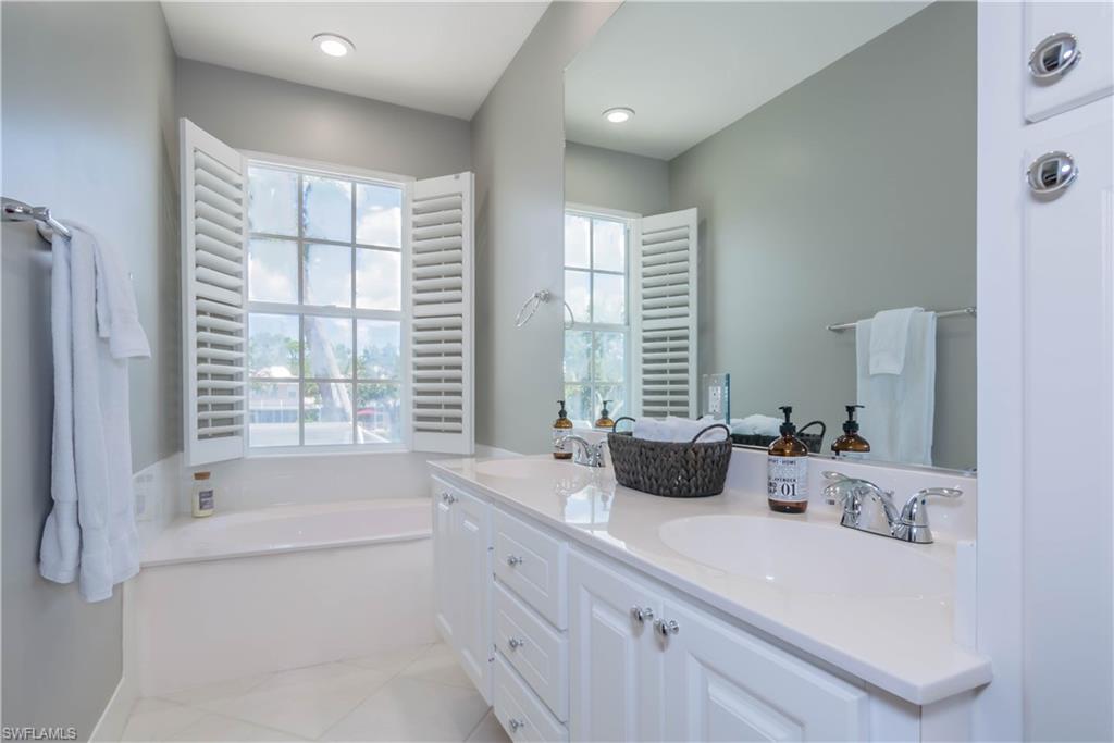 5441 Cove Circle Naples, FL 34119 - Photo 16 of 25 a bathroom with sink double vanity and bathtub