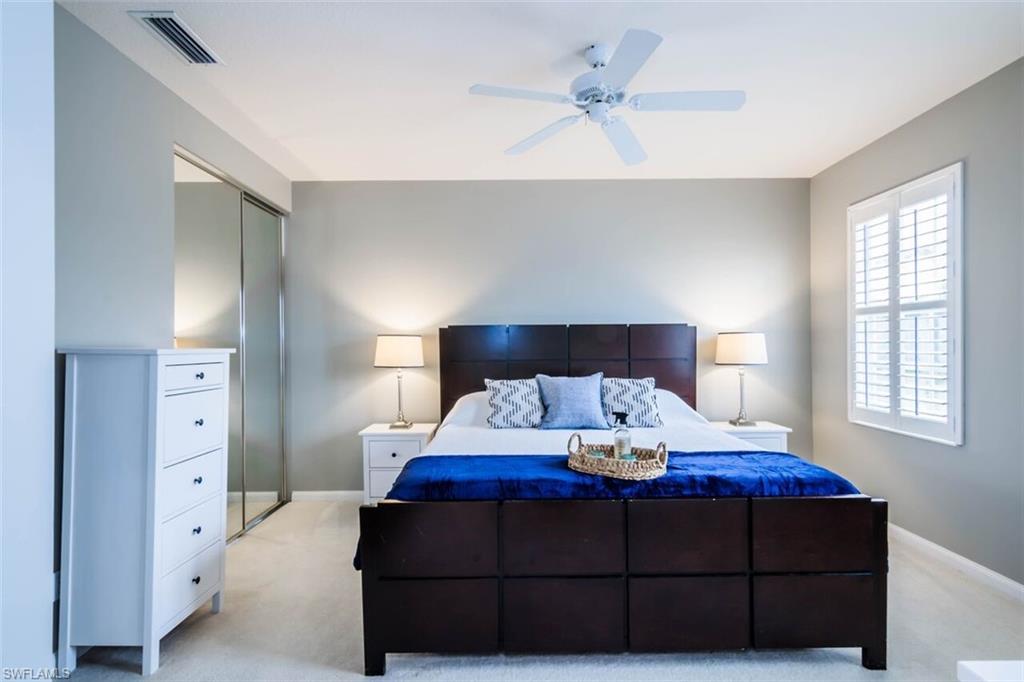 5441 Cove Circle Naples, FL 34119 - Photo 18 of 25 a bedroom with a bed and a lamp on dresser