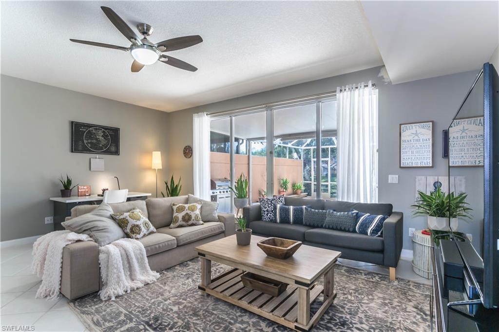 5441 Cove Circle Naples, FL 34119 - Photo 5 of 25 a living room with furniture ceiling fan and a large window