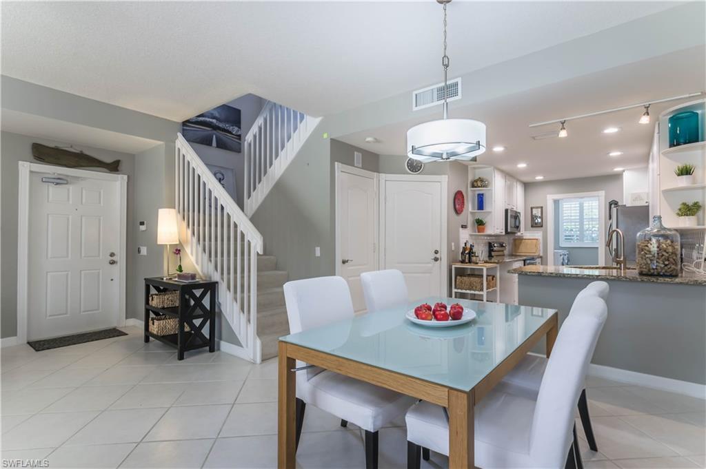 5441 Cove Circle Naples, FL 34119 - Photo 10 of 25 a view of a dining room and livingroom with furniture wooden table and a chandelier