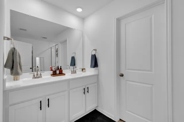 a bathroom with mirror and window