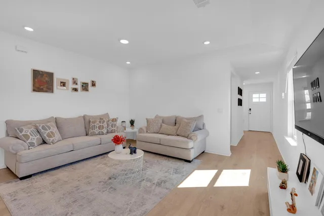 a living room with furniture and wooden floor