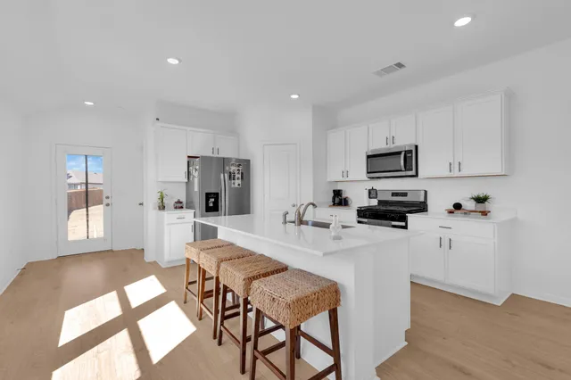 a kitchen with stainless steel appliances granite countertop a sink stove and refrigerator