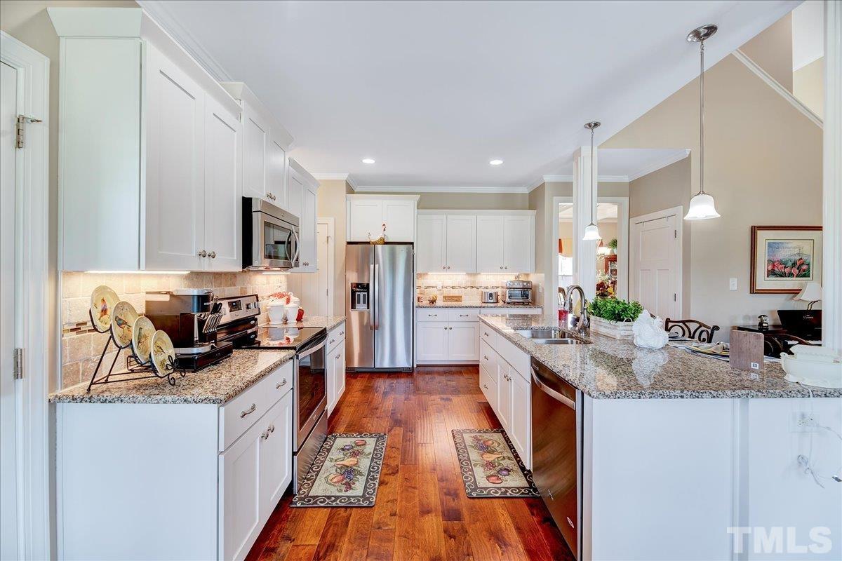 97 Baldwin Ridge Court Willow Spring, NC 27592 - Photo 11 of 46 a kitchen with stainless steel appliances granite countertop a sink stove and refrigerator