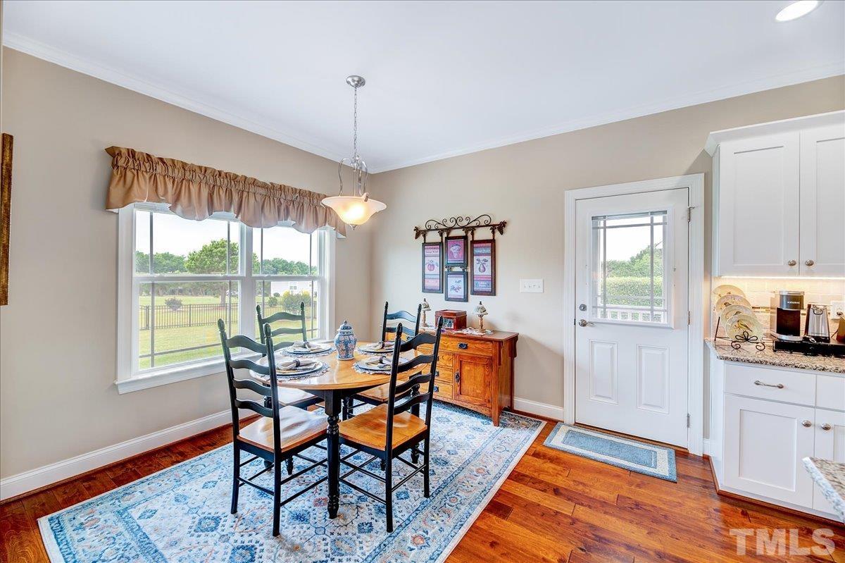 97 Baldwin Ridge Court Willow Spring, NC 27592 - Photo 18 of 46 a dining room with furniture a chandelier and wooden floor