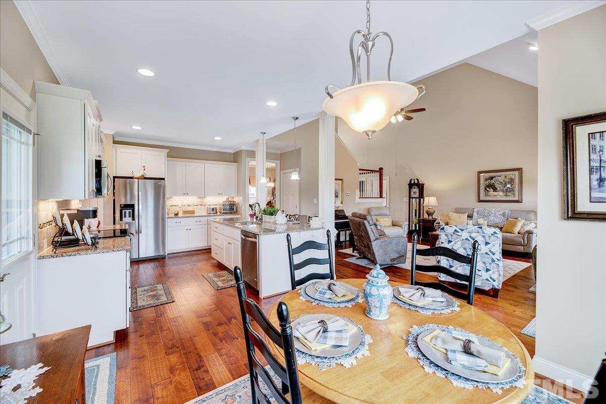 97 Baldwin Ridge Court Willow Spring, NC 27592 - Photo 19 of 46 a view of a dining room and livingroom with furniture wooden floor a chandelier