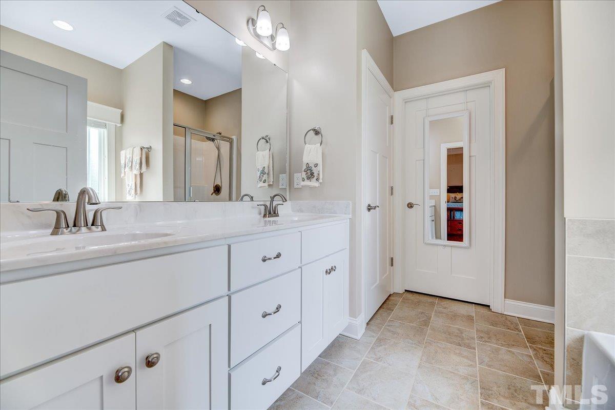 97 Baldwin Ridge Court Willow Spring, NC 27592 - Photo 24 of 46 a spacious bathroom with double sink and a mirror
