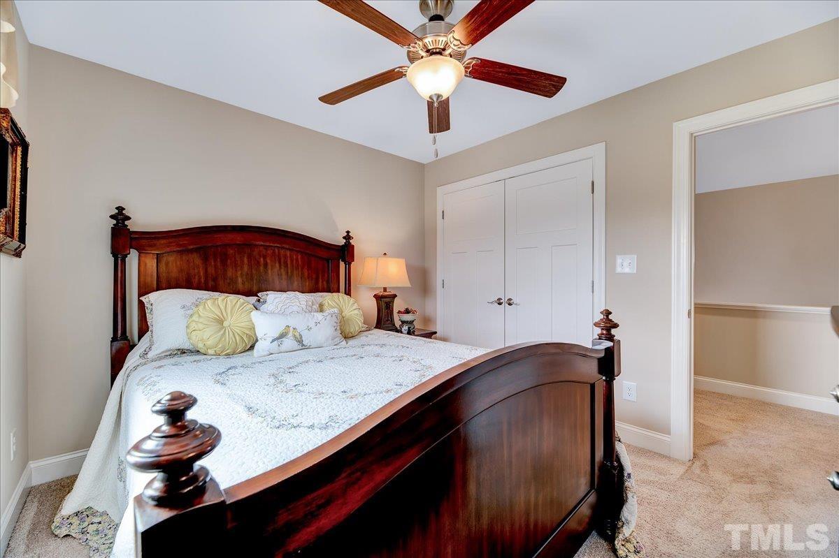 97 Baldwin Ridge Court Willow Spring, NC 27592 - Photo 26 of 46 a bedroom with a bed and a chandelier