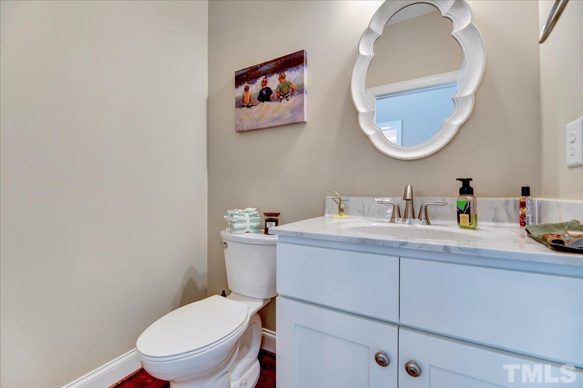 97 Baldwin Ridge Court Willow Spring, NC 27592 - Photo 6 of 46 a bathroom with a toilet a sink and mirror