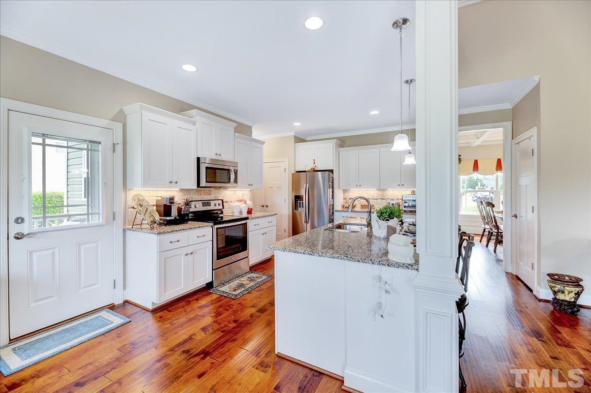 97 Baldwin Ridge Court Willow Spring, NC 27592 - Photo 10 of 46 a kitchen with white cabinets and stainless steel appliances