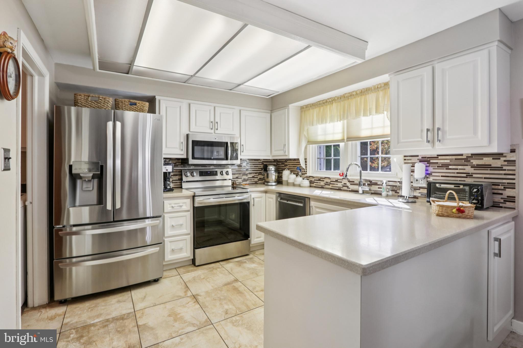 102 Partree Road Cherry Hill, NJ 08003 - Photo 30 of 87 a kitchen with kitchen island a counter top space cabinets stainless steel appliances and a window
