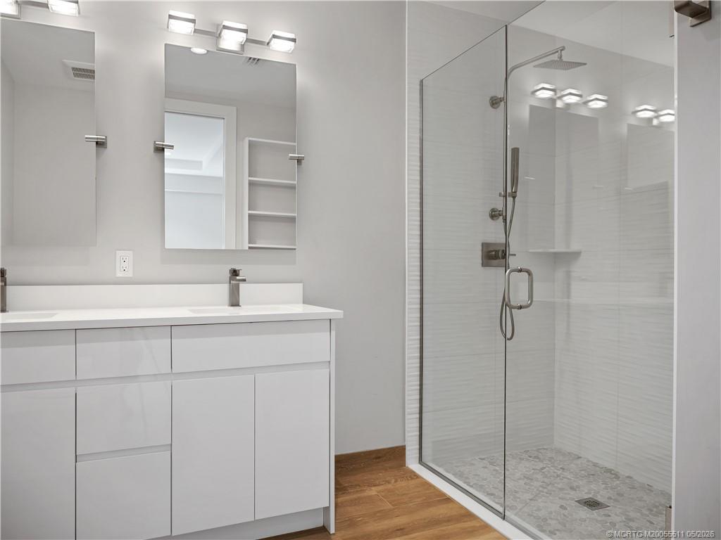 41 Southwest Seminole Street, Unit 208 Stuart, FL 34994 - Photo 28 of 46 a bathroom with a shower sink and mirror