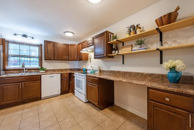 a kitchen with stainless steel appliances granite countertop a refrigerator stove and sink