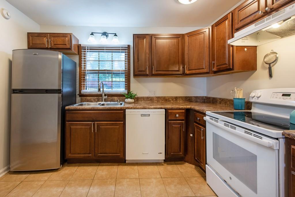 408 Sycamore Drive, Unit D Decatur, GA 30030 - Photo 12 of 63 a kitchen with stainless steel appliances granite countertop a refrigerator stove and sink