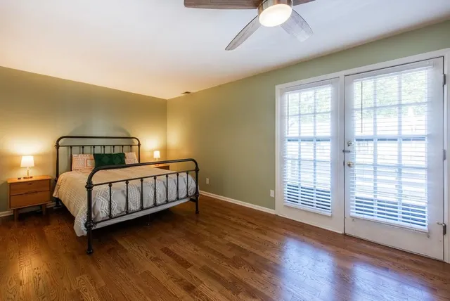 a bedroom with a bed a mirror and a window