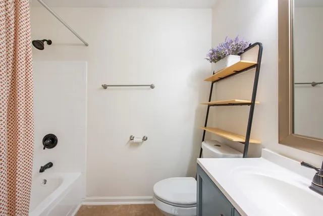 a bathroom with a sink vanity mirror and toilet
