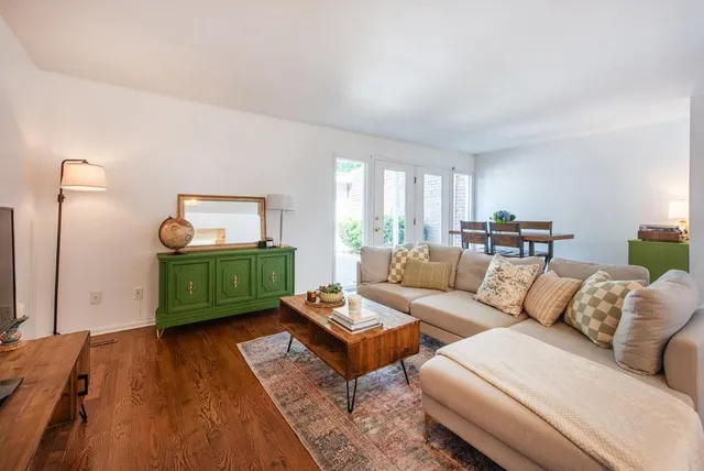 a living room with furniture and a wooden floor