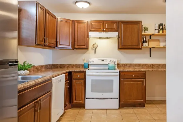 a kitchen with stainless steel appliances granite countertop a sink stove and cabinets
