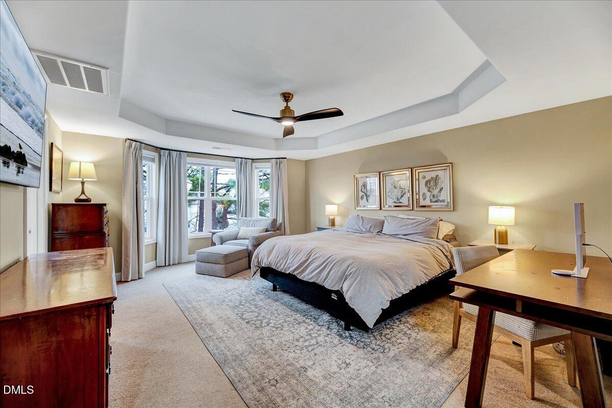 454 Big Willow Way Rolesville, NC 27571 - Photo 11 of 50 a bedroom with a large bed and a chandelier