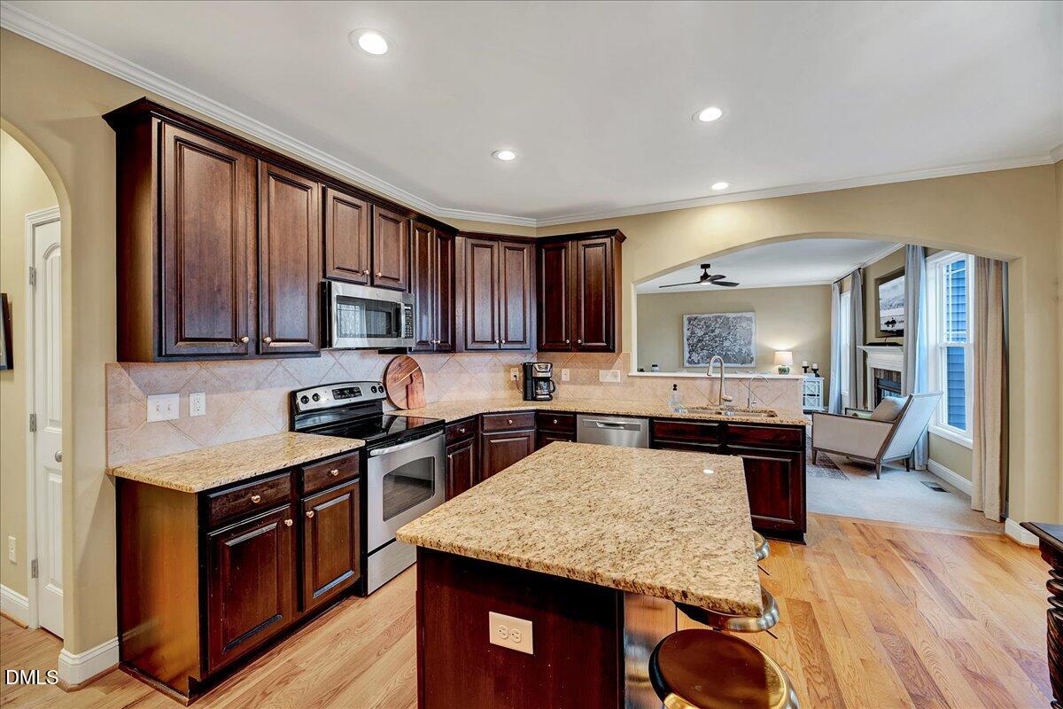454 Big Willow Way Rolesville, NC 27571 - Photo 18 of 50 a kitchen with stainless steel appliances granite countertop wooden cabinets a stove top oven a sink and dishwasher