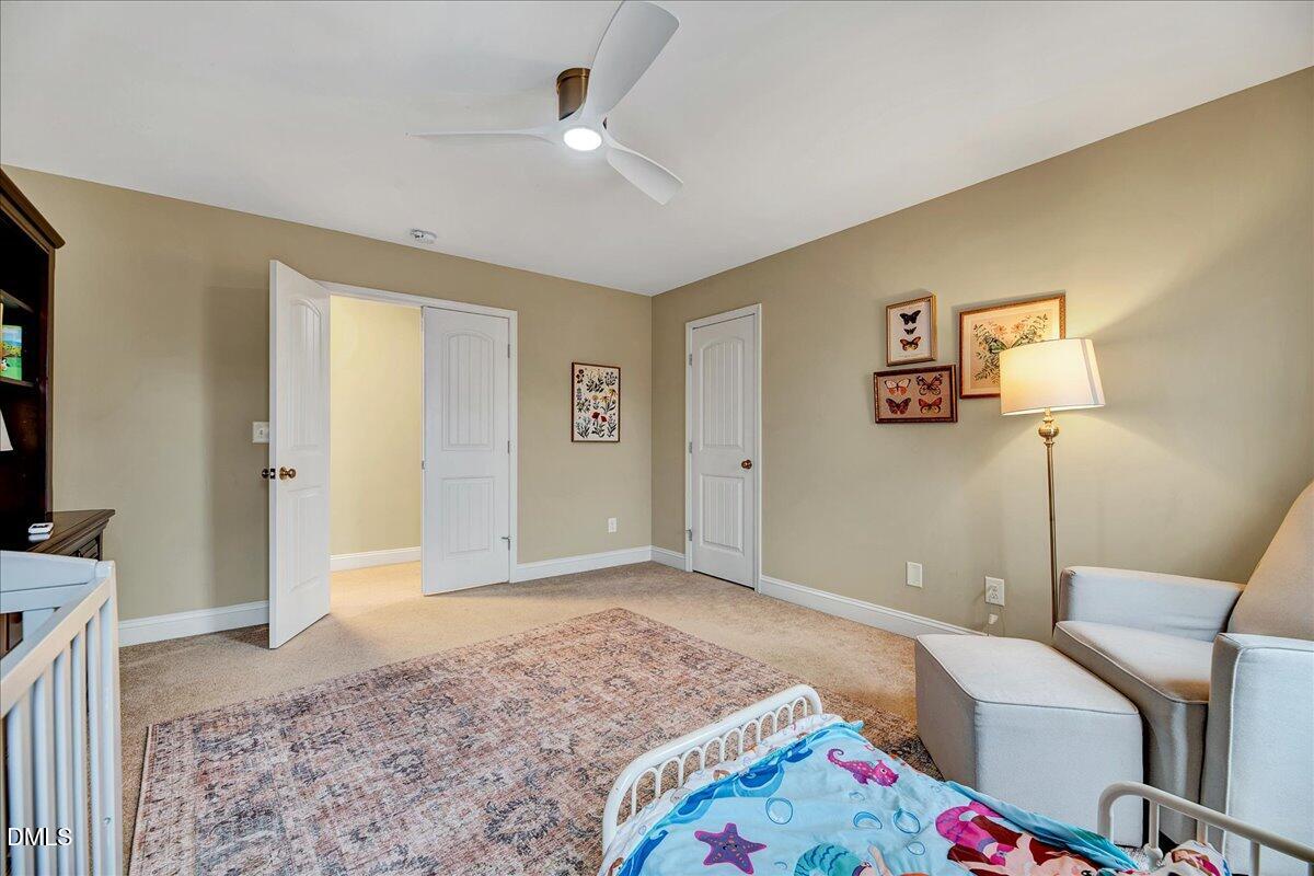 454 Big Willow Way Rolesville, NC 27571 - Photo 25 of 50 a spacious bedroom with a bed and a lamp on table