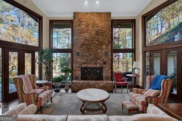 a living room with furniture a fireplace and large windows