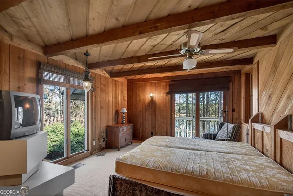 a bedroom with a large bed and large windows