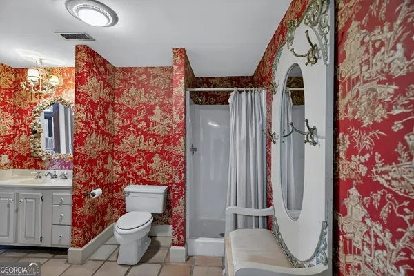 a bathroom with a toilet sink and shower curtain