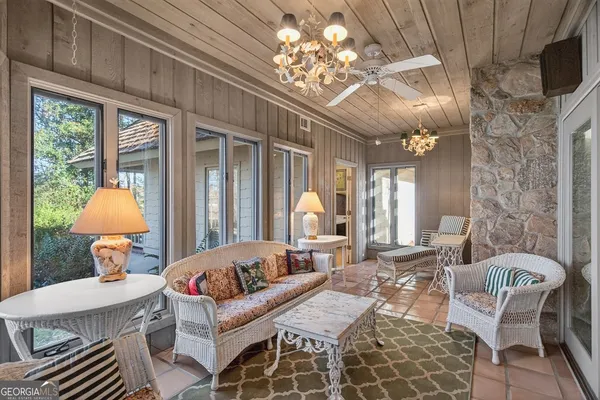 a living room with furniture a chandelier and a large window