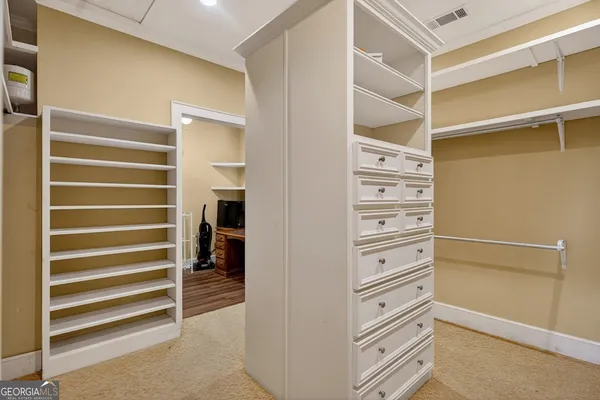 a view of walk in closet with empty racks