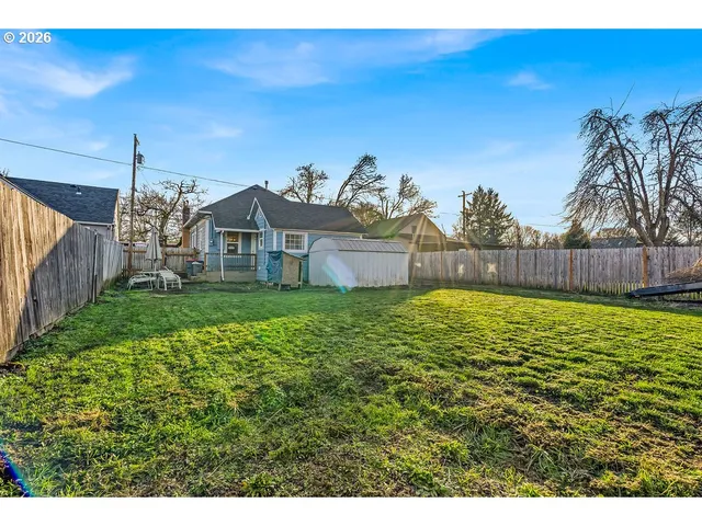 a backyard of a house with table and chairs