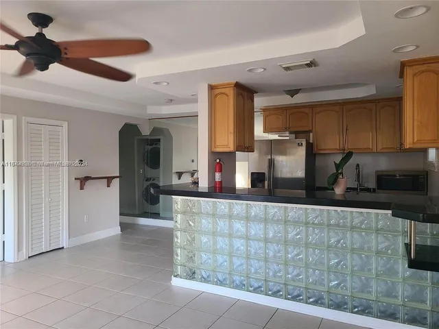 a kitchen with stainless steel appliances granite countertop a sink and a refrigerator