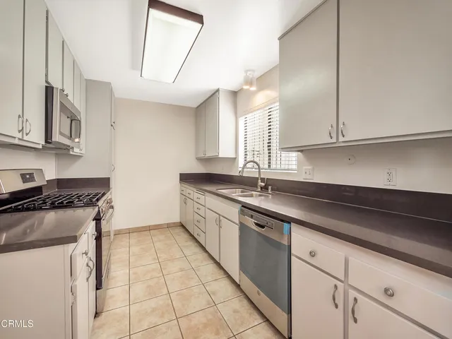a kitchen with stainless steel appliances granite countertop a sink stove and cabinets