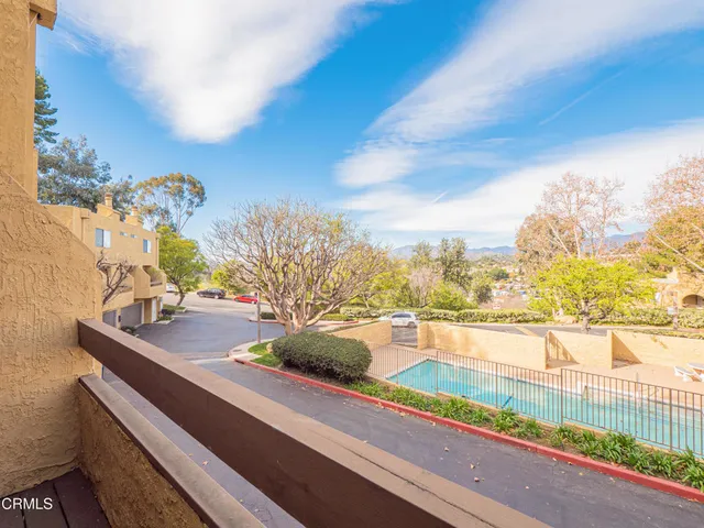 a view of a hallway with wooden floor and a bathroom