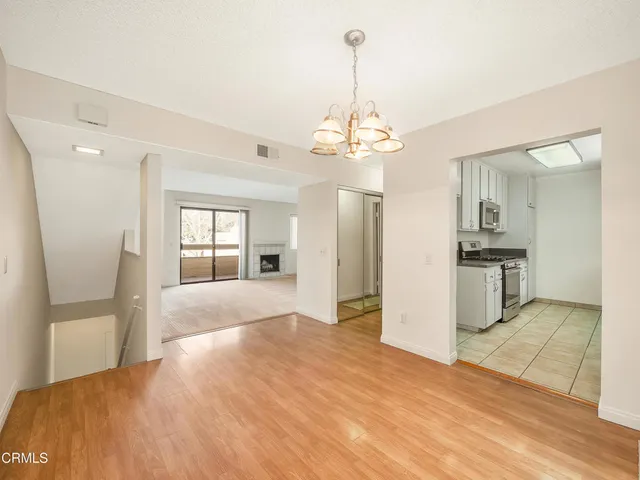 a view of a kitchen with refrigerator and wooden floor