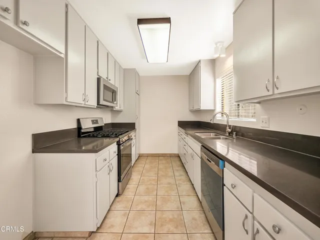 a kitchen with stainless steel appliances granite countertop a sink stove and cabinets