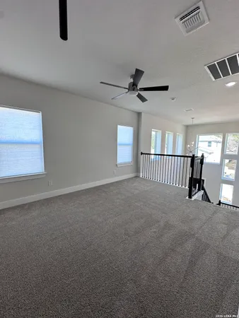 en empty room with windows and ceiling fan