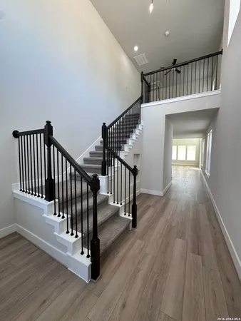 a view of a hallway with wooden floor and staircase