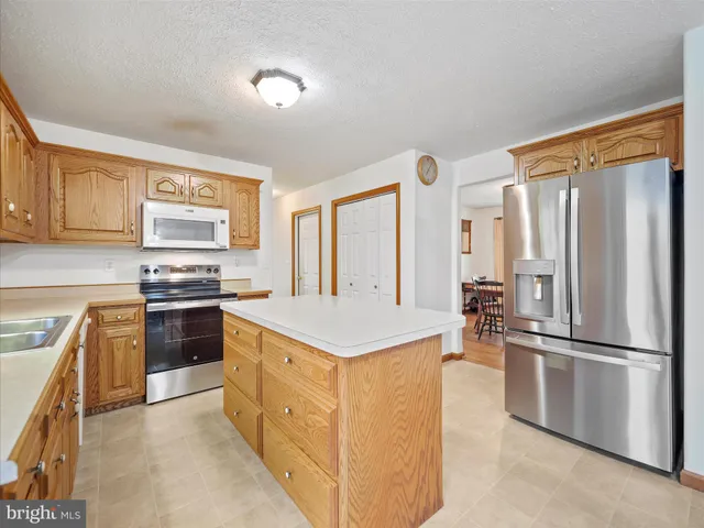 a kitchen with stainless steel appliances granite countertop a refrigerator a stove a sink and a refrigerator