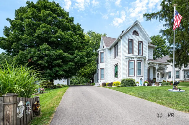 a front view of a house with a yard and trees