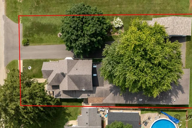 an aerial view of green landscape with trees houses and lake view