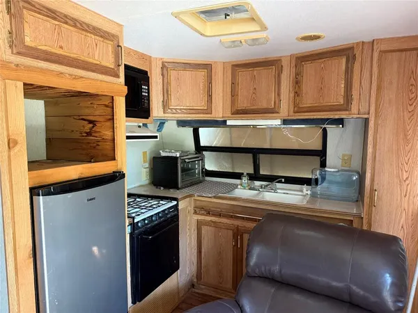 a kitchen with a stove a sink and a microwave